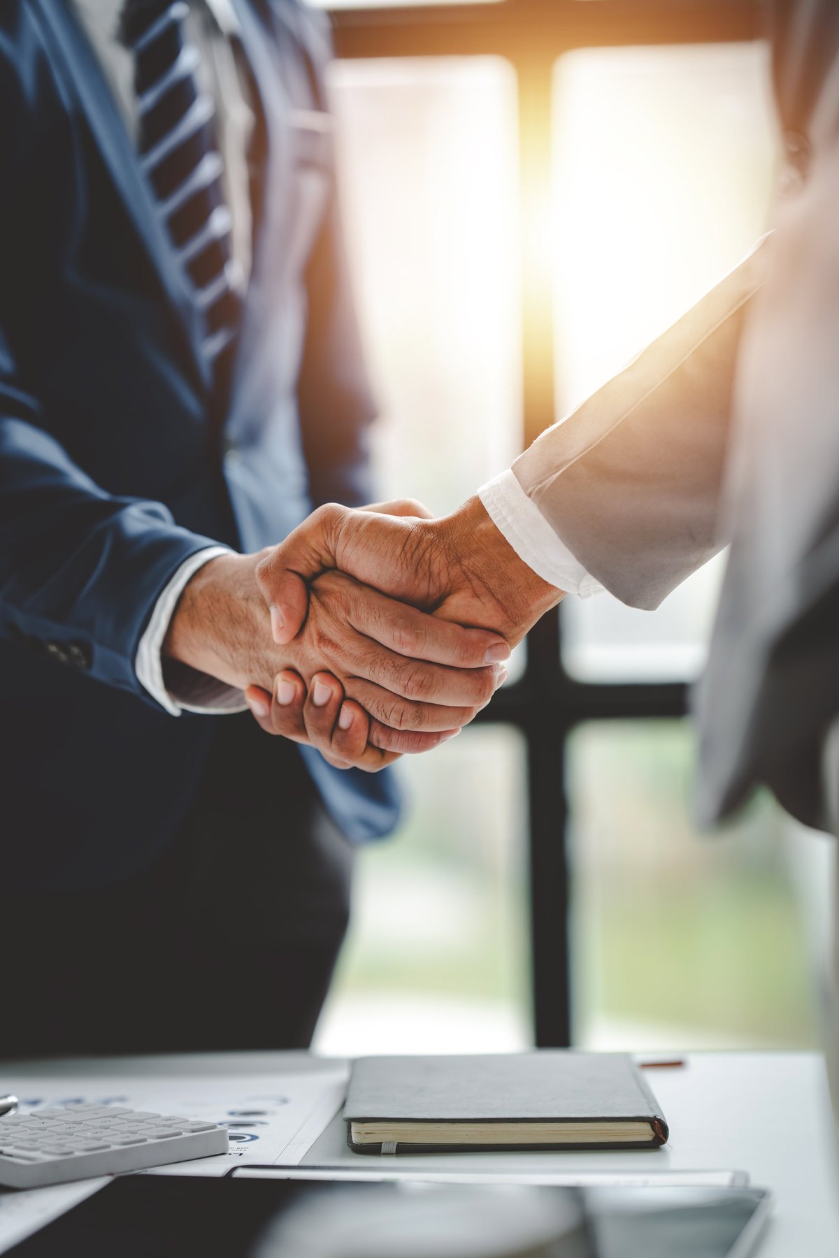 Business partners shaking hands after a successful meeting, with a blurred background