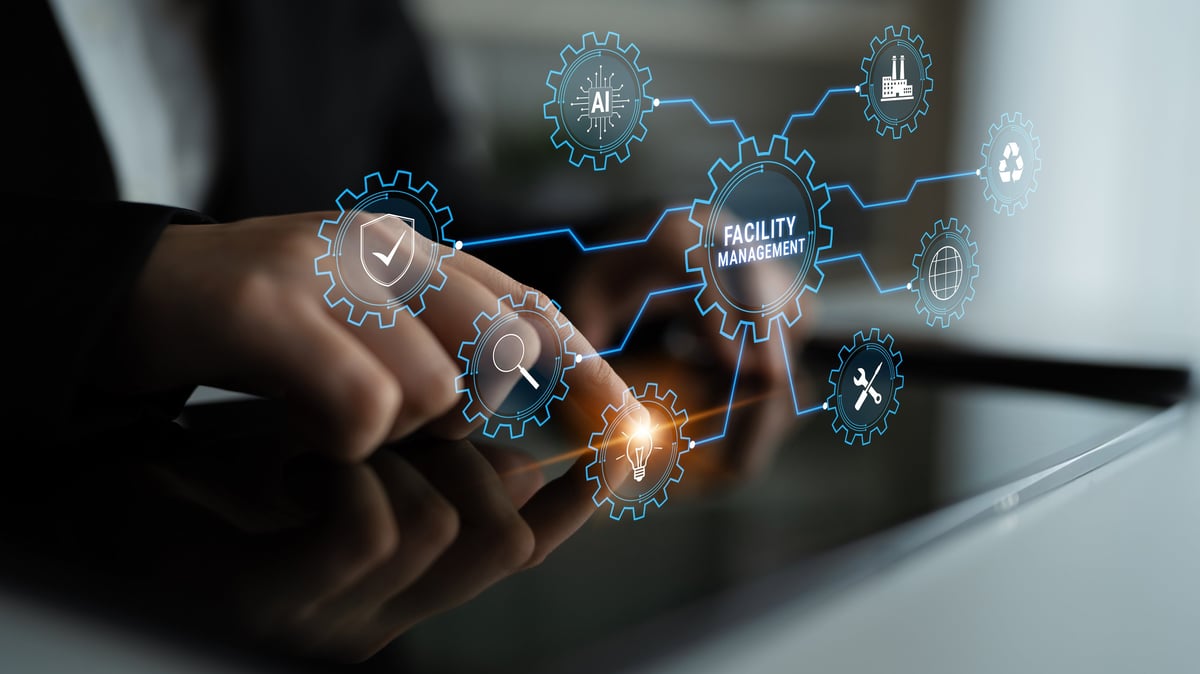 A close-up of hands interacting with a tablet displaying gear icons connected by digital pathways